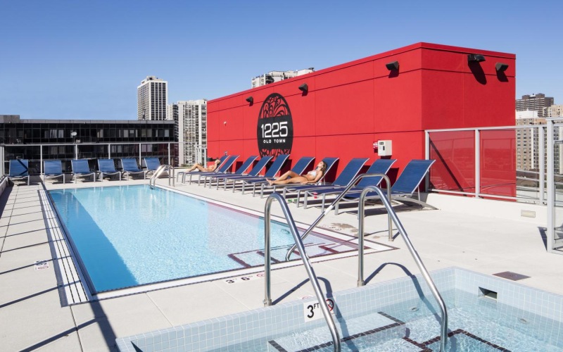a swimming pool with a red building in the background